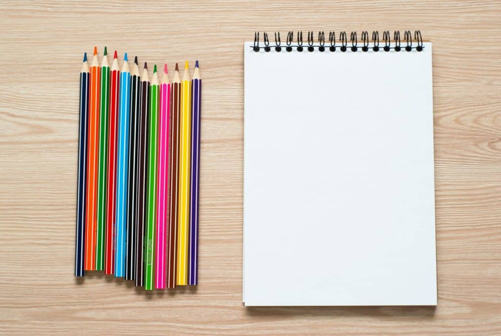 Pencils and notebook on a desk.