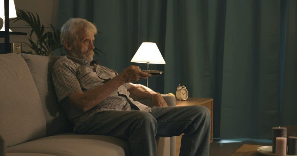 Elderly man watching television at night